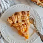 Peach pie using canned peaches 2 Slice of peach pie using canned peaches on a white plate with a fork